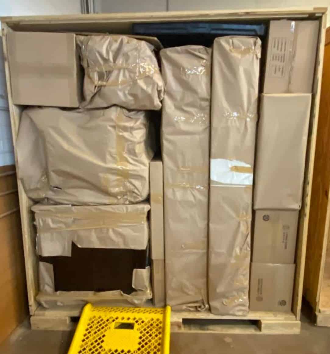 Furniture wrapped in protective paper inside a wooden storage vault