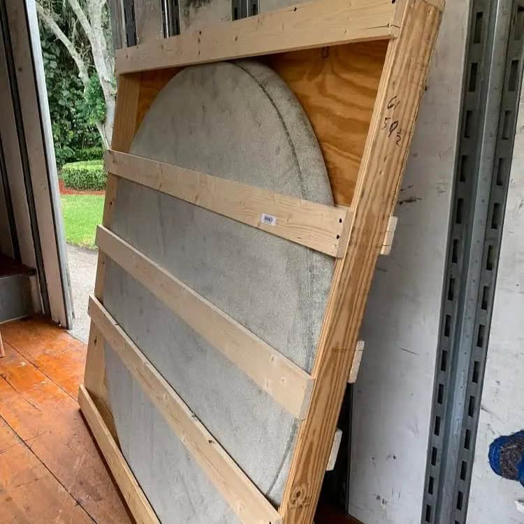 Round stone tabletop secured in a custom wooden crate, ready for transport